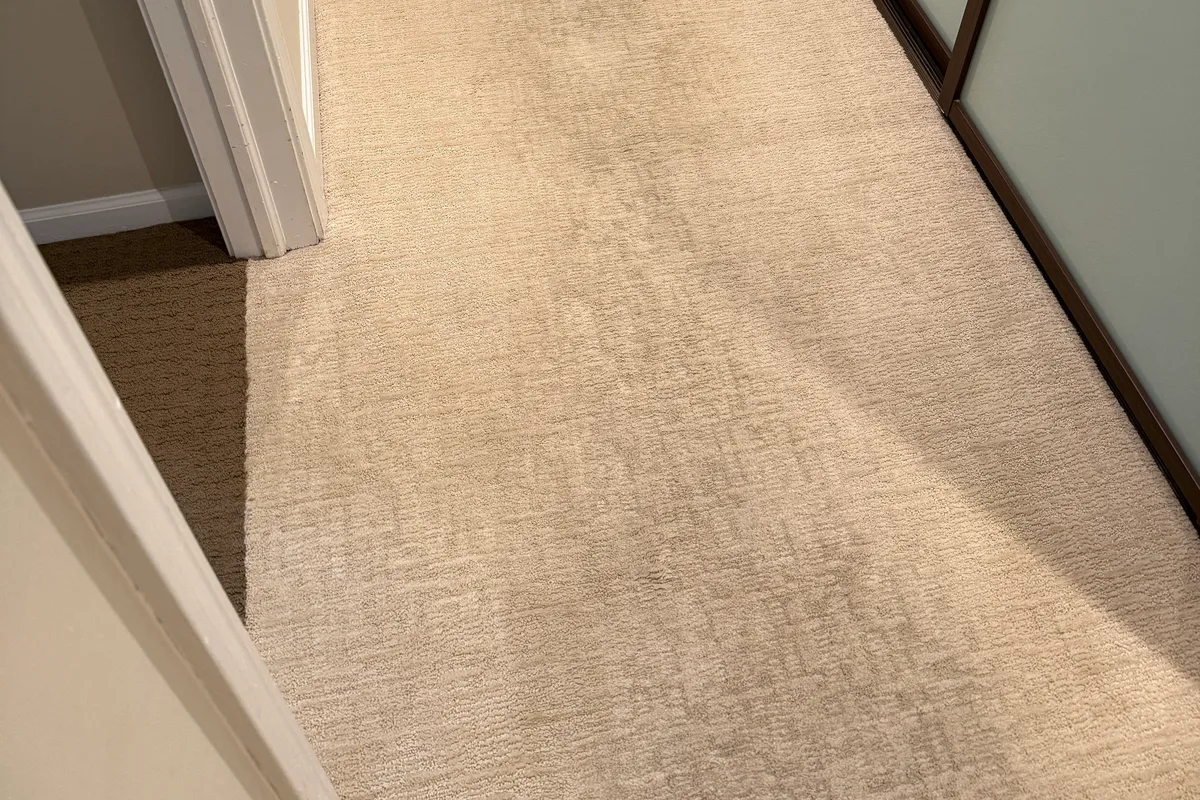 Northbrook carpet with darkened traffic lane worn through the main walking route before cleaning