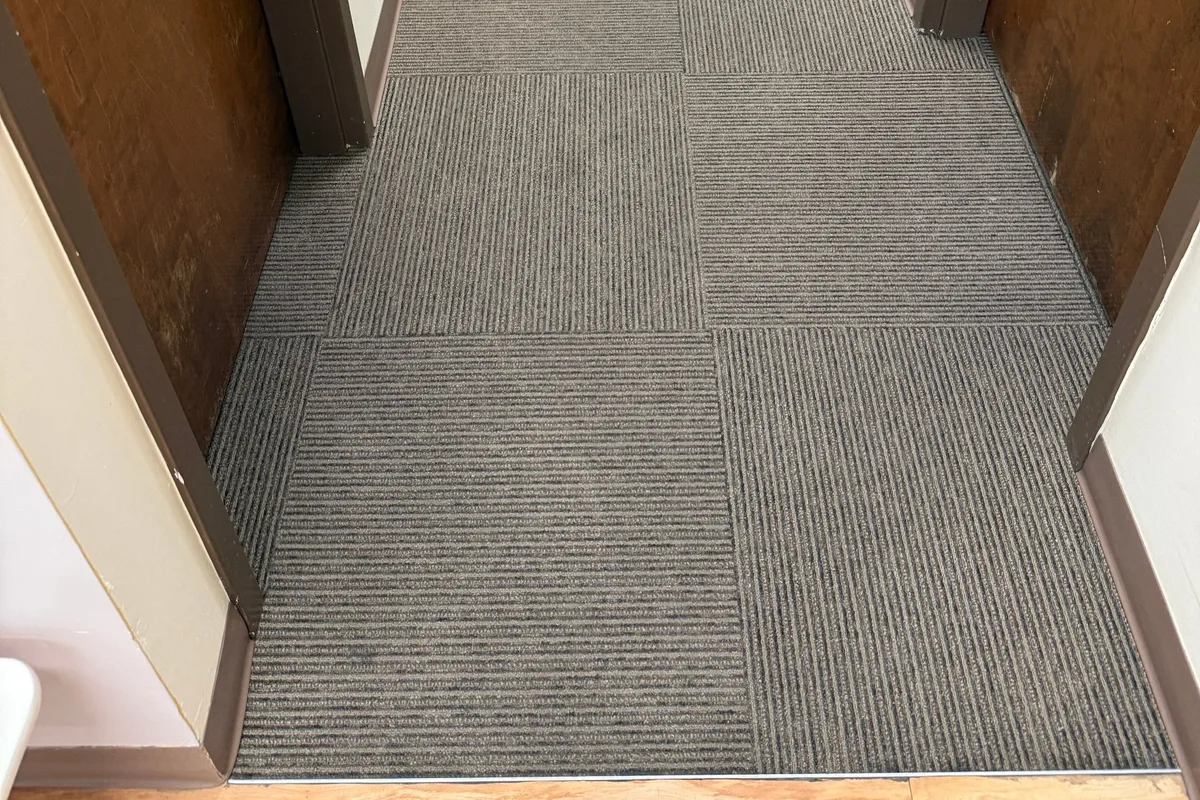 Same office carpet tile after hot-water extraction, traffic lanes evened out