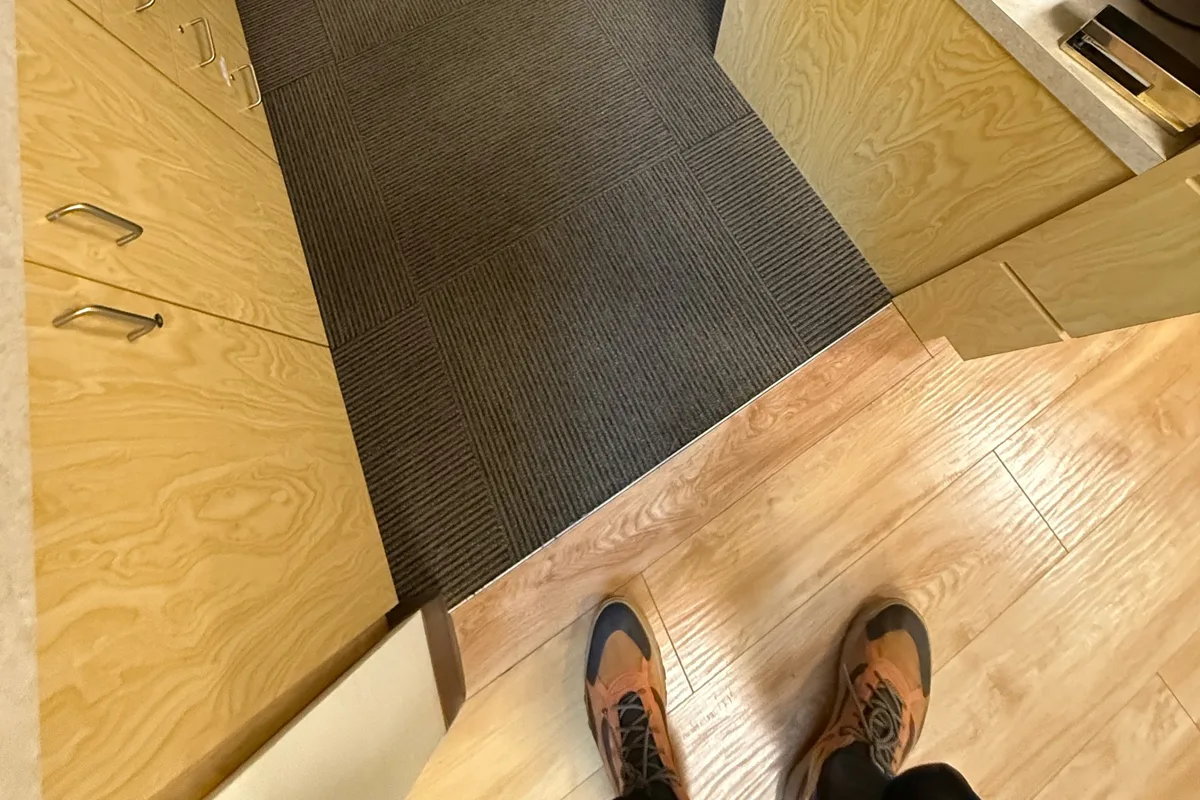 Wand passing over commercial carpet tile during hot-water extraction in the office