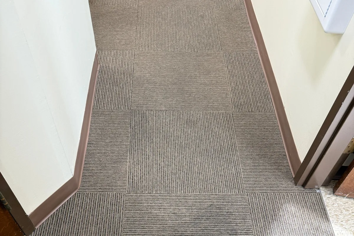Coffee spill on carpet tile receiving spot treatment before extraction