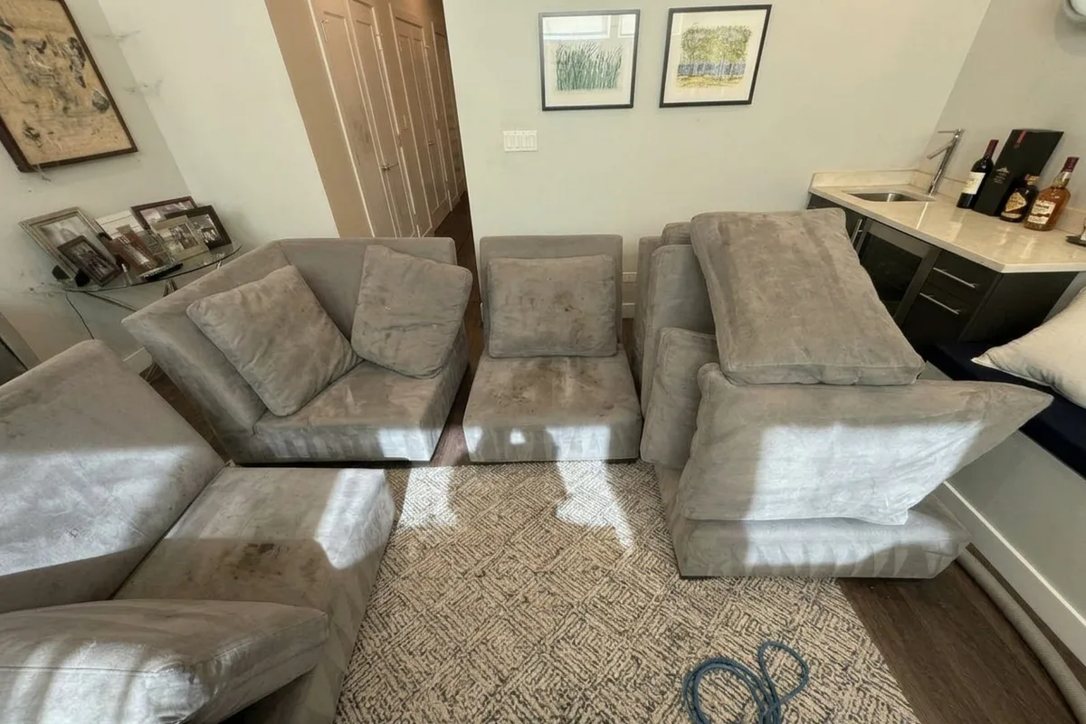 Large L-shaped sectional with cat hair settled along seat seams before cleaning in Chicago