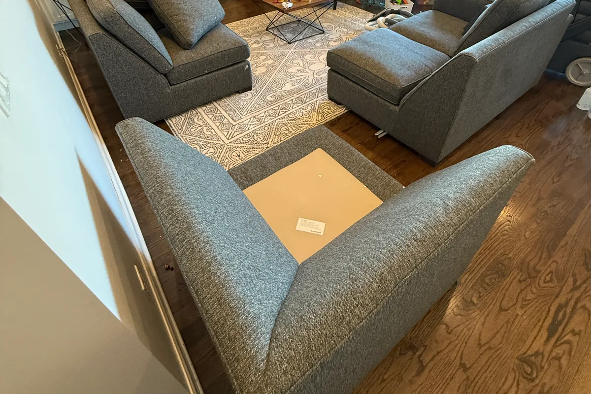 Upholstery tool passing across a seat cushion of the large sectional