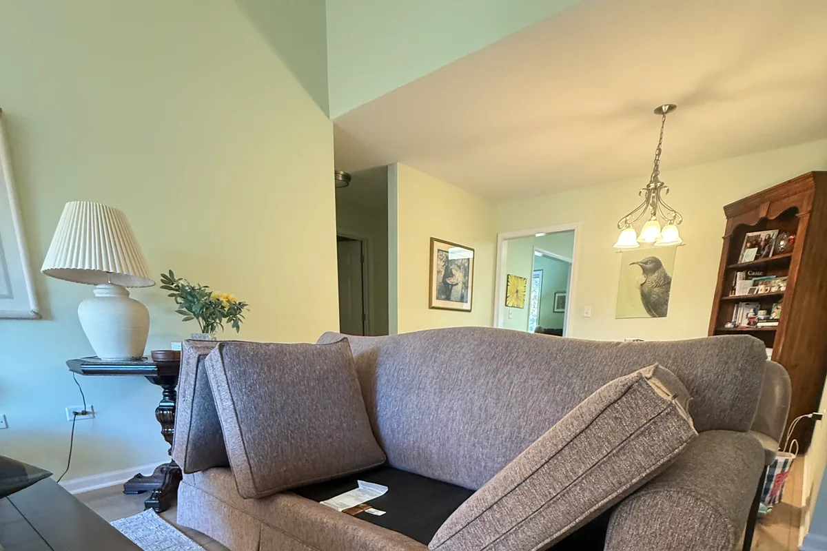 Technician working along loveseat seams and piping during upholstery cleaning